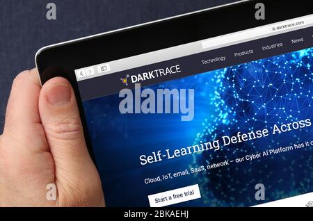 A man looking at the website for Darktrace a cyber-security developer on his iPad. (Editorial Use Only) Stock Photo