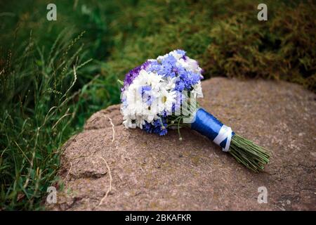 A bouquet of flowers rests on a rock in the summer Stock Photo