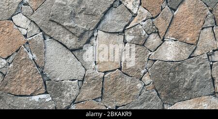 Rock texture, stone wall background. Mosaic pattern of old grey stones on floor. Wide panorama, panoramic banner. Grunge architecture facade, tiled fr Stock Photo