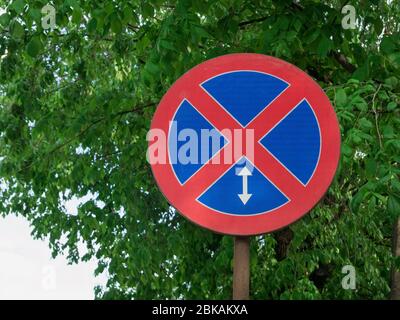 No parking road sign. Street sign with green leaves in the background. Stock Photo