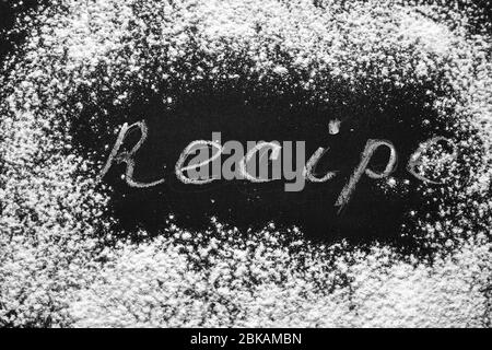 Headline recipe sprinkle flour on a black table. Banner recipe handwritten word. Stock Photo