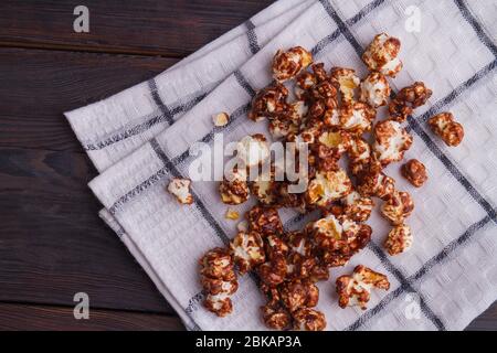 Scattered chocolate popcorn grains on white napkin. Stock Photo