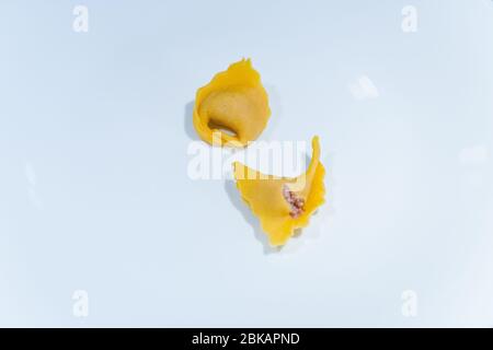 Two tortellini on a plate, one in a perfect shape the other it's broken Stock Photo