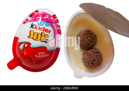 Kinder Joy egg with surprise showing both halves with one opened to show contents set on white background Stock Photo