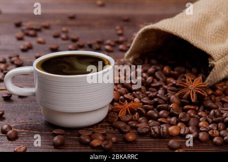 Cup of hot coffee and coffee beans with anise. Stock Photo