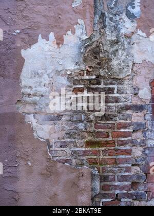 Old wall with peeling paint stucco exposed brick Stock Photo