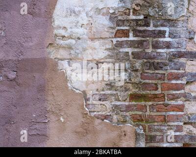 Old wall with peeling paint stucco exposed brick Stock Photo