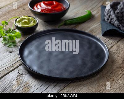 empty black plate on wooden kitchen table Stock Photo