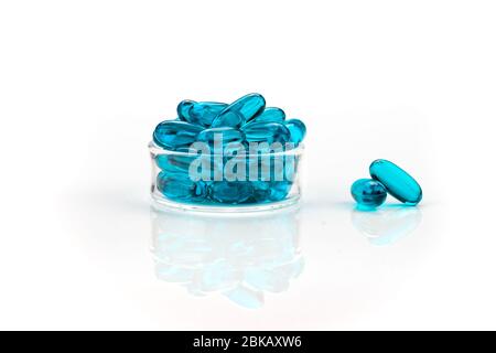 Close-up of blue medical soft gel capsules on a white background - medical supplements Stock Photo