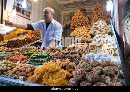 Moroccan sweet and Pastry vendor in Marrakesh market with multi-colored pastries on display in large quantity, Marrakesh, Morocco, North Africa Stock Photo