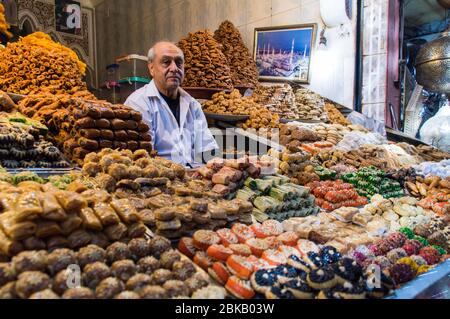 Moroccan sweet and Pastry vendor in Marrakesh market with multi-colored pastries on display in large quantity, Marrakesh, Morocco, North Africa Stock Photo