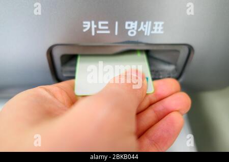 hand inserting card into ATM Stock Photo