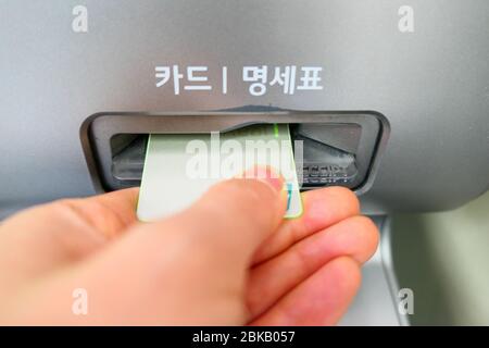 hand inserting card into ATM Stock Photo