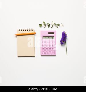 Work and study place, notebook and digital calculator and pencil with dry flower on white background. flat lay, top view, copy space Stock Photo