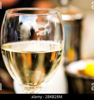 Close Up Of A Refreshing Glass Of Chilled White Wine, On A Table Top Setting, With No People, With An Out Of ficus Background Stock Photo