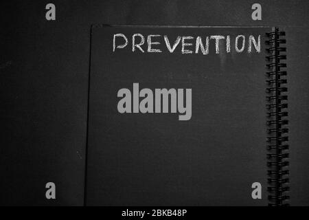 Prevention word written on a notepad with blank space. Blank black notepad background. Stock Photo