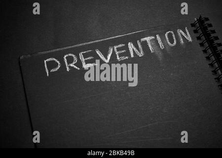 Prevention word written on a notepad with blank space. Blank black notepad background. Stock Photo