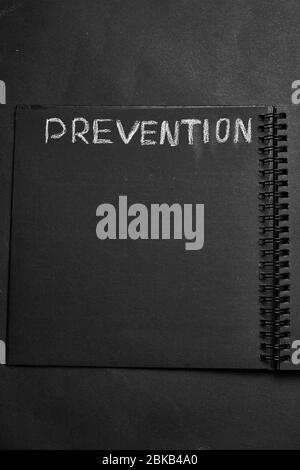 Prevention word written on a notepad with blank space. Blank black notepad background. Stock Photo