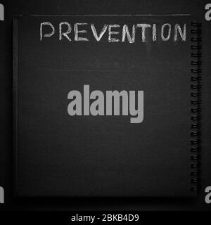 Prevention word written on a notepad with blank space. Blank black notepad background. Stock Photo