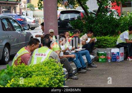 Macau / China - July 26, 2015: Construction workers taking a lunch break in Macau, China
