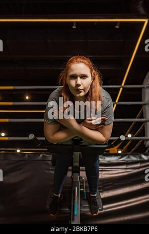 low angle view of focused overweight girl doing lower back extension exercise on training machine Stock Photo