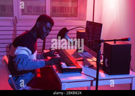 Music production concept - Male sound producer working in home recording studio. Stock Photo