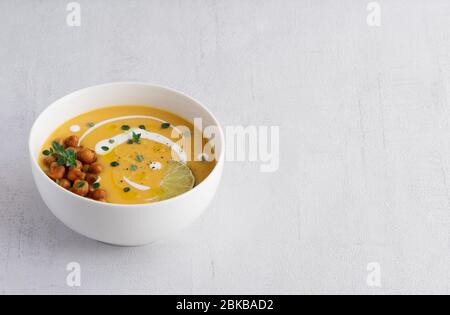 Pumpkin vegetarian cream soup isolated on grey background. Copy space. Stock Photo