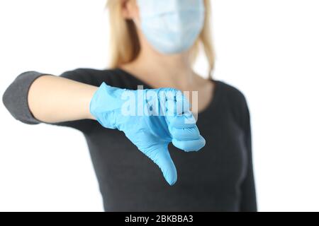 Close up of woman hand with thumbs down avoiding covid-19 with mask and gloves isolated on white background Stock Photo