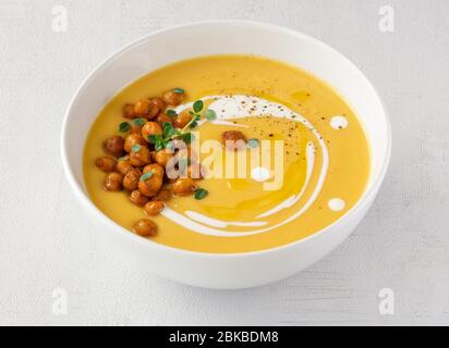 Pumpkin cream soup with spicy chickpeas. Close up. Isolated.  Stock Photo