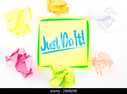 A yellow sticky note with the inspirational quote encouraging people to Just Do It rather than thinking and delaying. Stock Photo