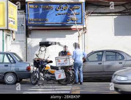 Emergency rescue mechanic on motorcycle helping broken down motorist  in Teheran, Iran, Persia, Middle East. Stock Photo