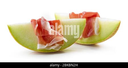 Melon slices with prosciutto ham isolated on white background Stock Photo