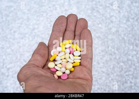 A handful of pills in the old man's hand. Many different pills in the palm of a man Stock Photo