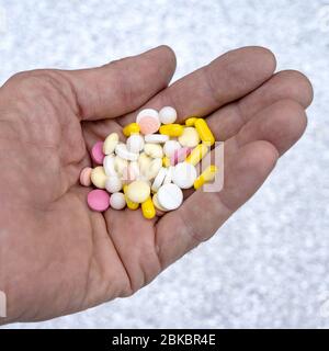 A handful of pills in the old man's hand. Many different pills in the palm of a man Stock Photo