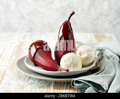 Plate of pears poached in red wine, dessert decorated with melted chocolate and ice cream Stock Photo