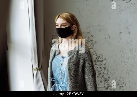 Young woman in medical mask stay isolation at home for self quarantine. Concept home quarantine, prevention COVID-19, Coronavirus outbreak situation. Stock Photo