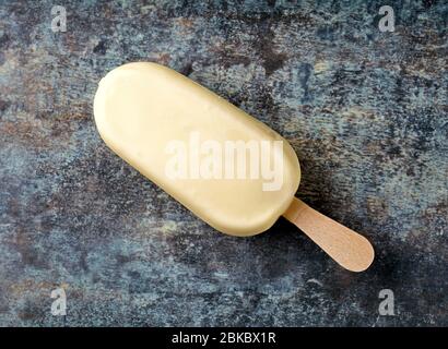 ice cream covered with white chocolate on colorful printed plate background, top view Stock Photo