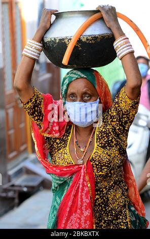 Beawar, India. 03rd May, 2020. An elderly rajasthani woman carry pot filled with drinking water on her head during the nationwide lockdown in wake of the novel coronavirus pandemic (COVID-19), in Beawar. (Photo by Sumit Saraswat/Pacific Press) Credit: Pacific Press Agency/Alamy Live News Stock Photo