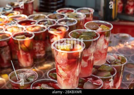 Pickled cucumber and cabbage slices with pickle juice in glass. Delicious and healthy street food. Stock Photo
