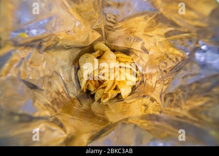 close-up view inside of a big silver bag of potato chips with selective focus Stock Photo