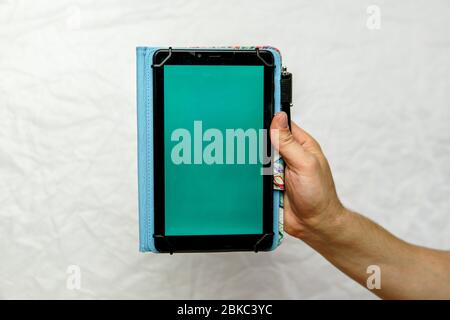 Tablet with green screen in hand on an isolated white background Stock Photo