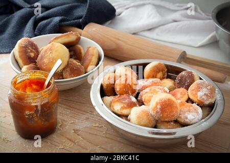 homemade donuts with jam in bowl on wooden table Stock Photo