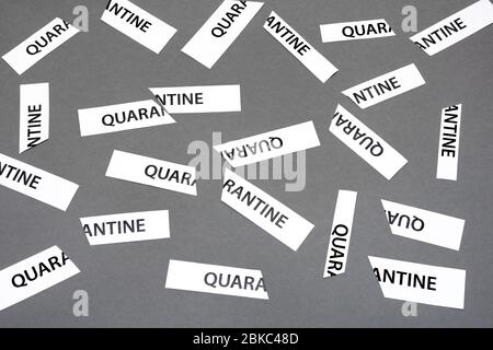 Tored apart paper with word quarantine printed on it. Quarantine is Over inscription on grey background. Conceptual background. End of a coronavirus Stock Photo