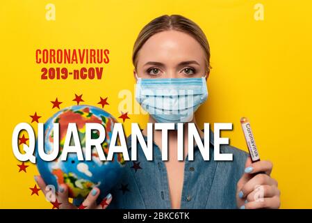 young woman in medical mask holding test tube with coronavirus blood sample and globe on yellow background, 2019-ncov and quarantine illustration Stock Photo