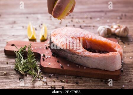 Fish Menu. Cook man plating salmon steak squeezing lemon juice. Selective Focus Stock Photo