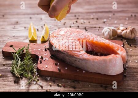 Fish Menu. Cook man plating salmon steak squeezing lemon juice. Selective Focus Stock Photo