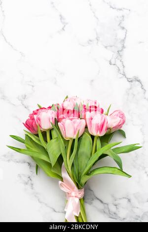 Bouquet of pink tulips on marble background with copy space for text or design Stock Photo