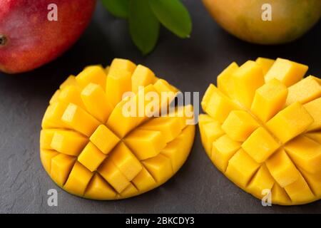 Tropical fruit mango cut in cubes on black background, closeup view. Fresh ripe mango Stock Photo