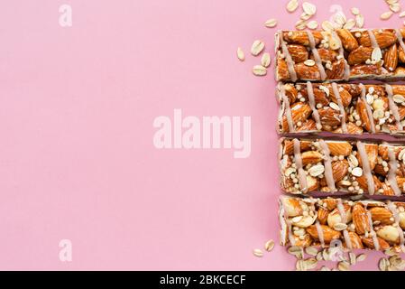 Granola nut bars on pink background. Healthy homemade protein bars. Copy space for text Stock Photo