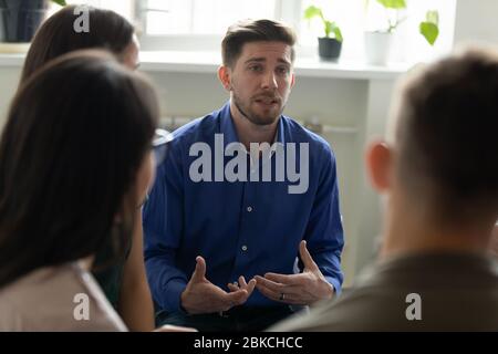 Confident serious male coach mentor talking holding briefing for team. Stock Photo